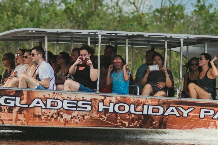 Group of people taking photos on an Everglades holiday tour boat.
